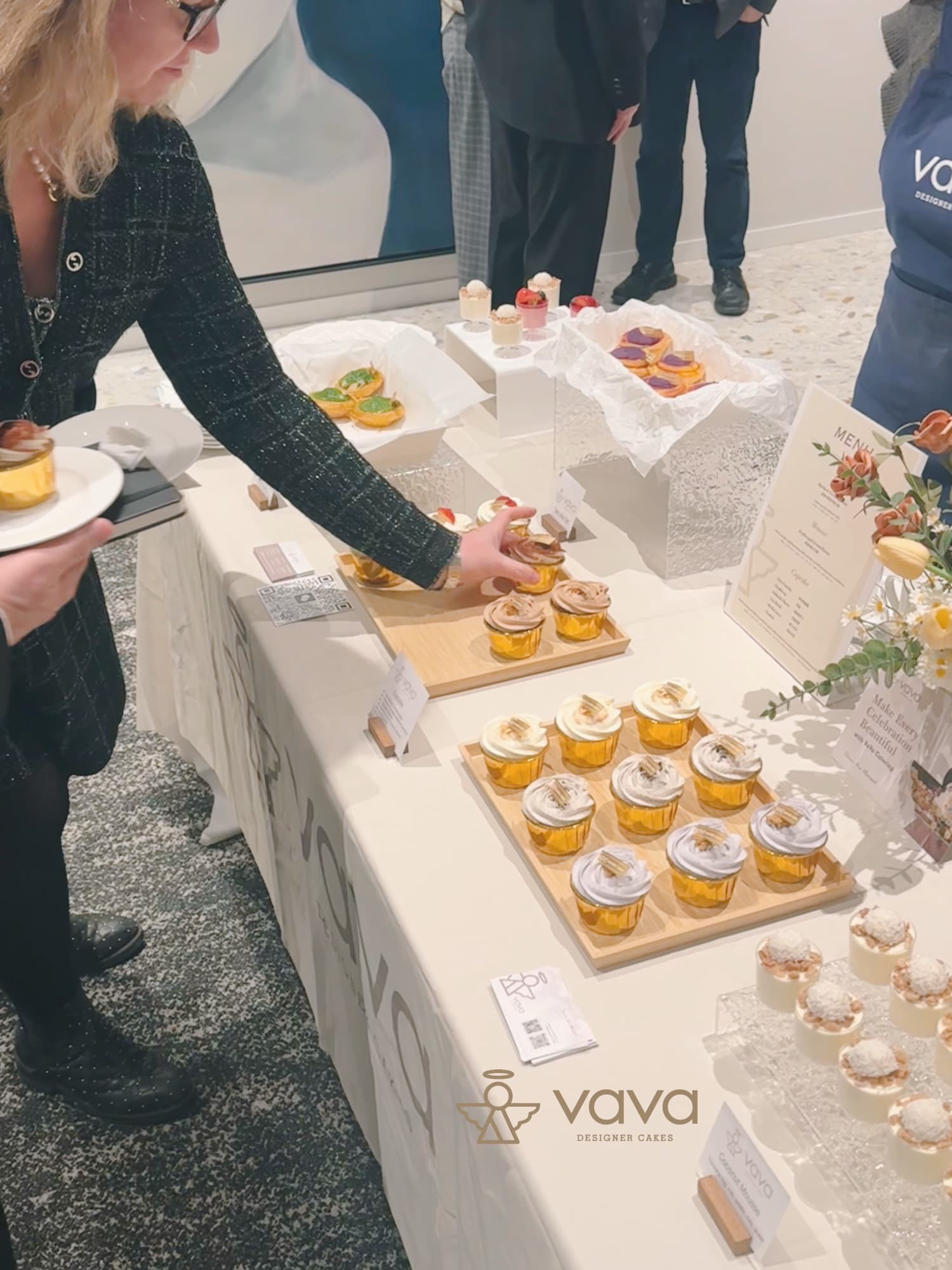 Guests serving themselves cupcakes and mini desserts from a Vava dessert station