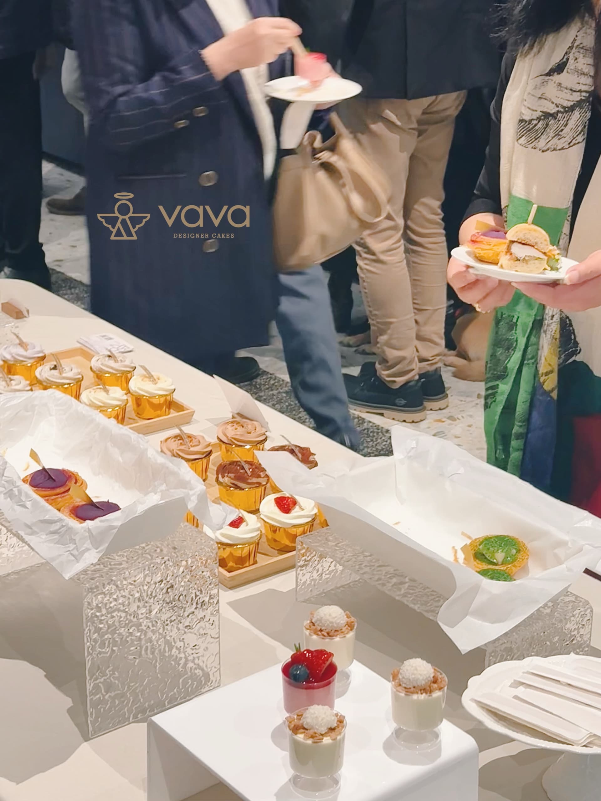 Guests at a Toronto evening party holding plates of Vava desserts and savoury bites